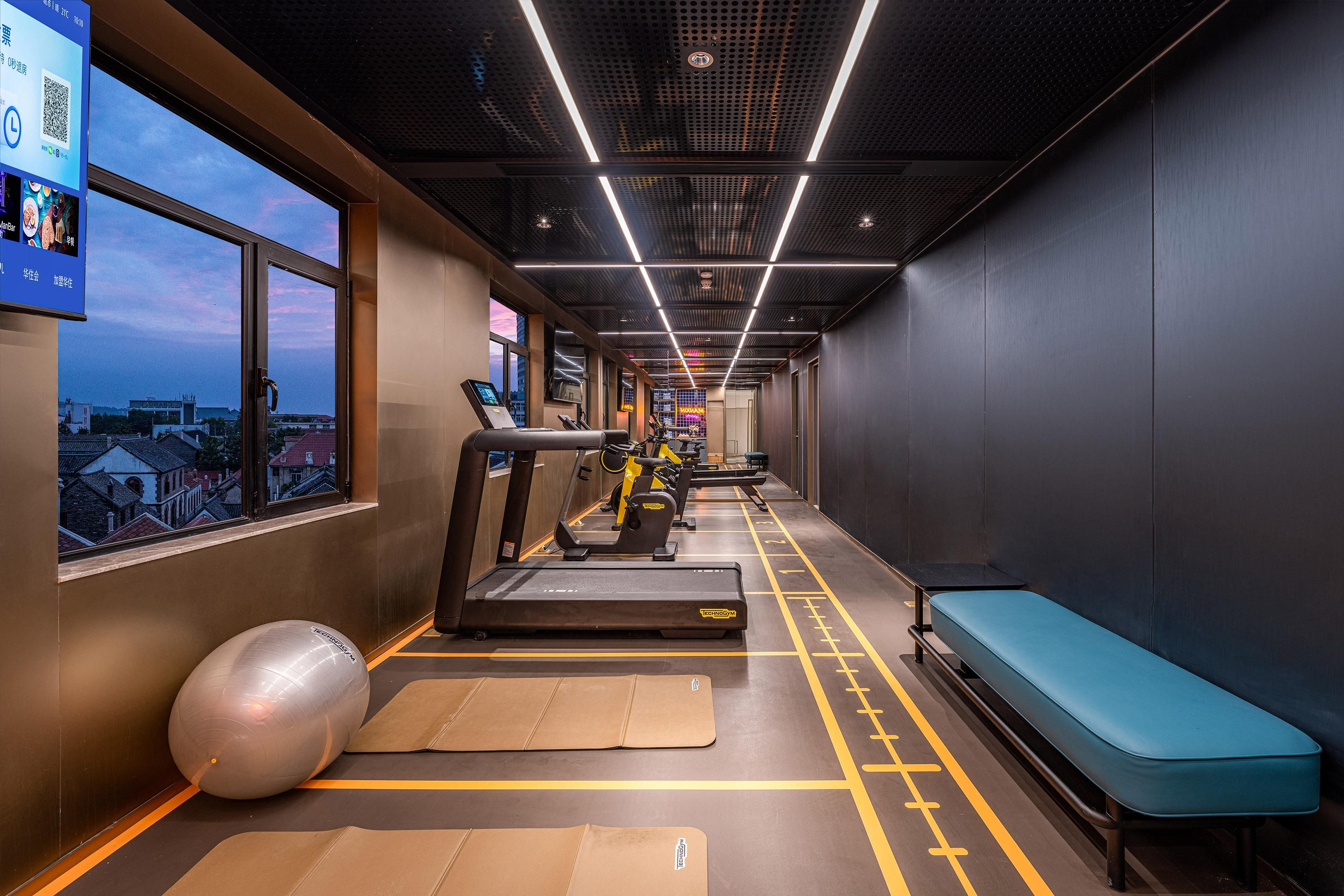 A gym with treadmills, exercise balls, and a bench.