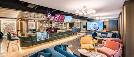 Un espace bar moderne, doté de sièges et d’un écran numérique affichant le menu.