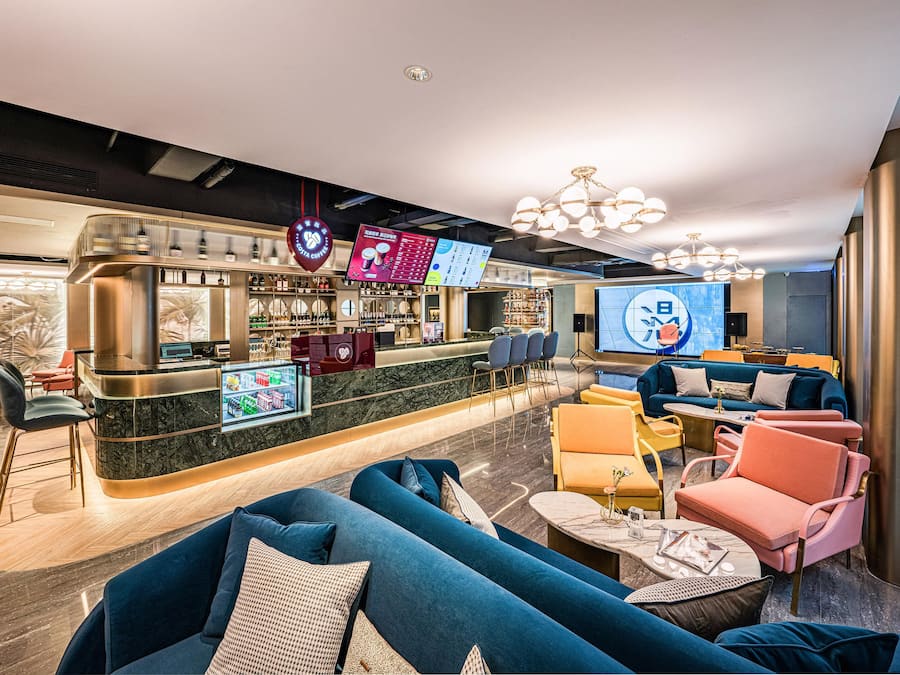 Eine moderne Bar mit Sitzgelegenheiten und einem digitalen Menü.