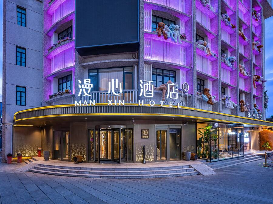 Un hotel con una entrada llamativa, un letrero con caracteres chinos y balcones decorados con peluches.