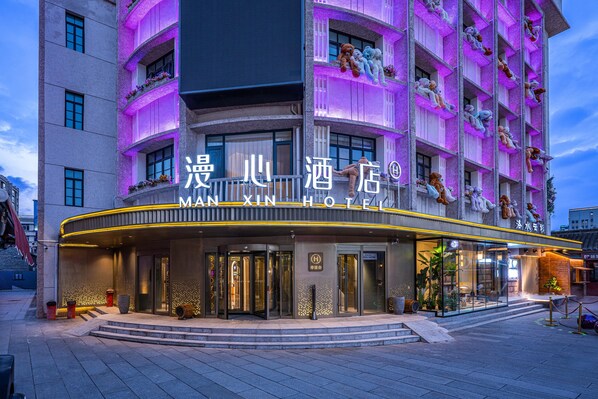 A hotel with a prominent entrance, a sign with Chinese characters, and balconies with plush toys. - Manxin Hotel Yantai Binhai Plaza (Yantai)