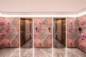A hallway with a floral mural and elevators. - Manxin Hotel Yantai Binhai Plaza (Yantai)