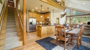 A spacious kitchen with wooden cabinets, a central island, and a dining area with a table and chairs. - Elk River Cabin -- Cabin Condo In Estes Park -- 23-zone3554 3 Bedroom Condo by RedAwning (Estes Park)