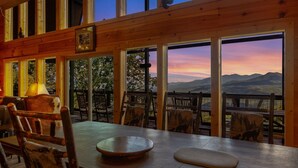 Un interior de madera con amplios ventanales que dan a un paisaje montañoso.
