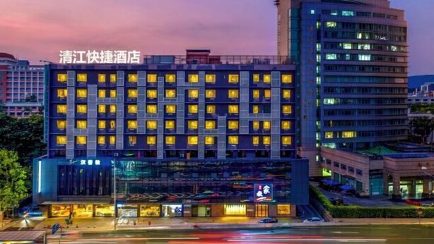 Un hotel con diversi piani, una facciata moderna e finestre illuminate.