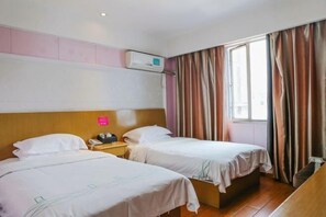 A hotel room with two beds, a wooden headboard, a nightstand with a phone, an air conditioning unit, and a window with curtains. - Qingjiang Express Hotel (Zhangshu)