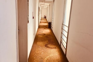 A long, narrow hallway with patterned carpet and doors on both sides. - Qingjiang Express Hotel (Zhangshu)