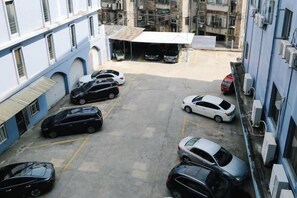A parking area with multiple cars parked in an urban setting. - Qingjiang Express Hotel (Zhangshu)