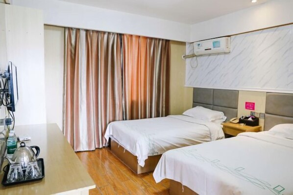 A hotel room with two beds, a desk with a kettle and tea set, a TV, and an air conditioning unit. - Qingjiang Express Hotel (Zhangshu)