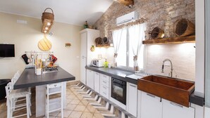 A modern kitchen with white cabinets, a black countertop, and a wooden backsplash. - 3888 Villetta tra Mari e Monti by Barbarhouse (San Giovanni Rotondo)