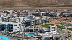 A modern residential area with multiple two-story buildings, a central swimming pool, and a landscaped park area. - Desert Dream Villa at Desert Color By Ember Stays (St. George)