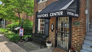A brick building with a black awning labeled "Visitors Center". There is a sign indicating "Historic Horse" and a plaque with the number "20".