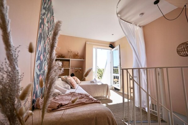 Une chambre à coucher avec un lit, une armoire, une fenêtre et un balcon.