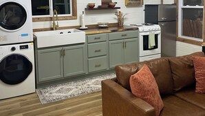 A compact kitchen with a washing machine, a stove, and a refrigerator.