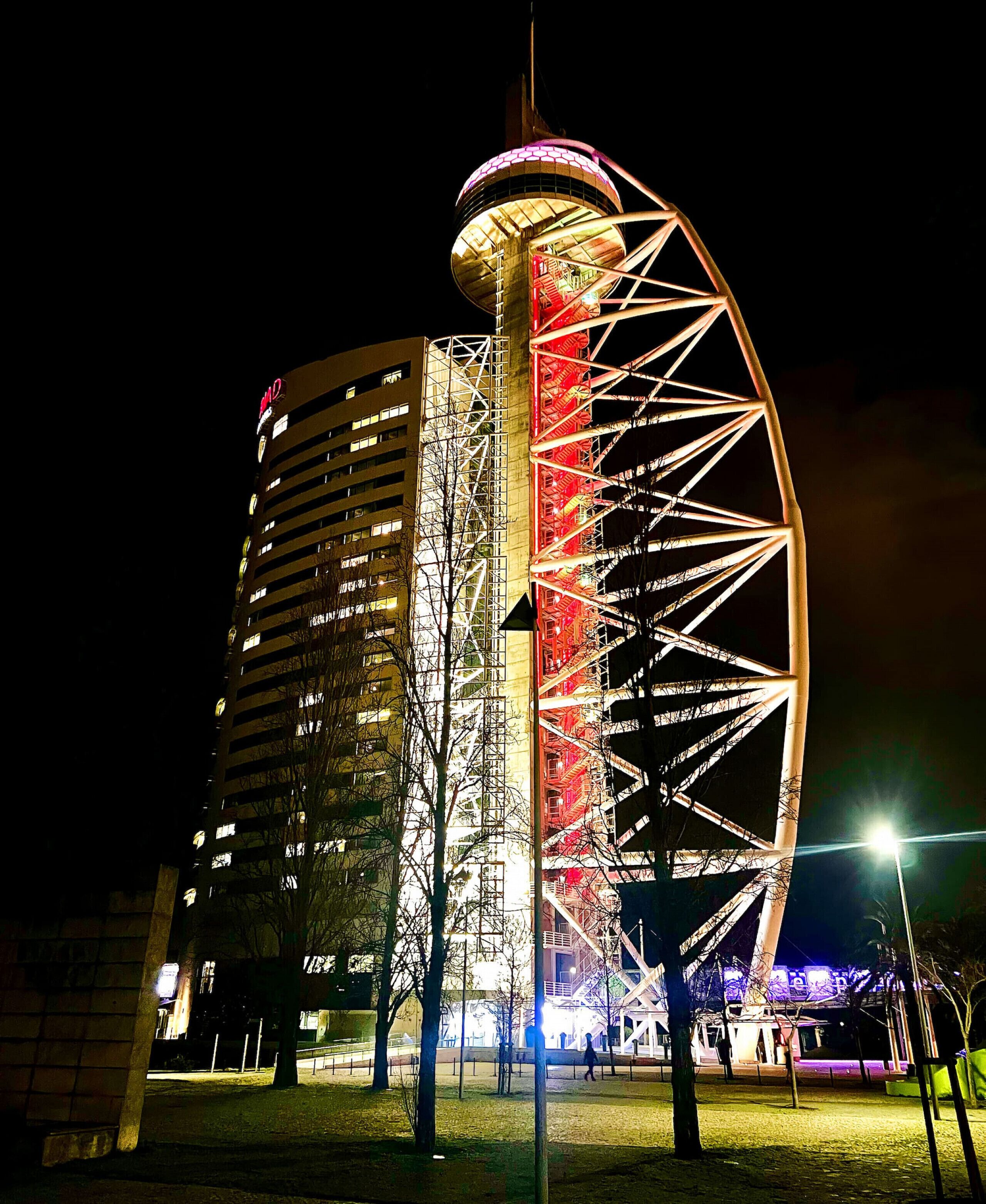 Un hotel de gran altura con una estructura curva distintiva y una gran atracción similar a una noria.