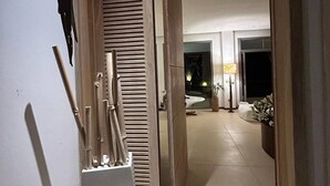 Un interior moderno con una puerta de madera que da a una habitación bien iluminada.