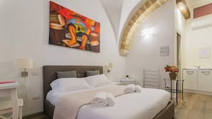 Une chambre d’hôtel moderne avec un grand lit, un bureau et un tableau au mur.