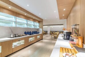 A modern kitchen with wooden cabinets, a marble countertop, and a glass display case. - Elong ME Hotel (Nanjing Lishui Airport Road) (Nanjing)