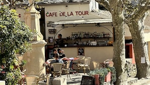 A cafe named 'Cafe de la Tour' with outdoor seating, a menu board, and a variety of bottles on the wall. - Apartement town Center, Rénové, 90m2 with balcony (saint florent)