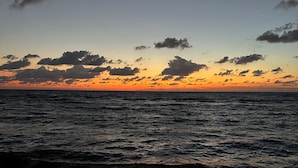 A beach with waves at sunset.
