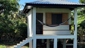 A small, single-story house with a porch and a hammock.