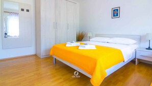 Una camera d'albergo con un letto grande, un armadio, un comodino e un tavolino.