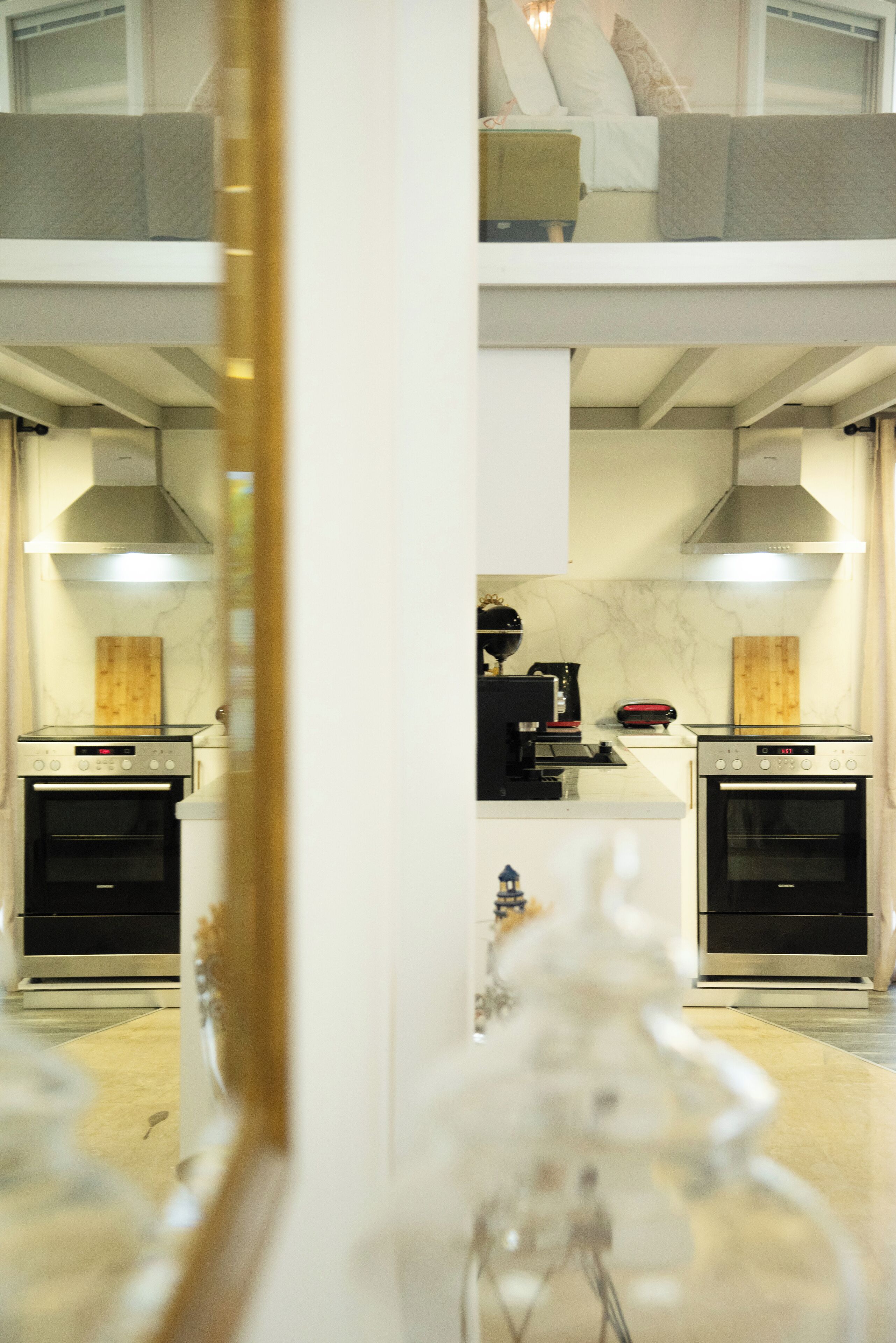A modern kitchen with two ovens, a microwave, and a coffee maker.