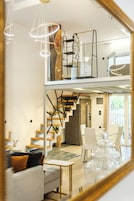 Un interior moderno con una escalera, un sofá y un comedor.
