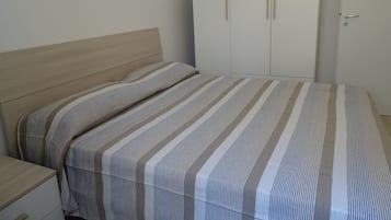 Un dormitorio con cama, mesita de noche y armario.