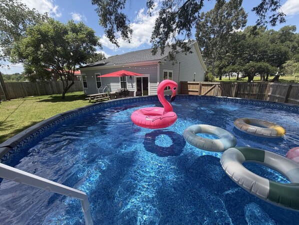 A swimming pool with inflatable rings and a flamingo float.