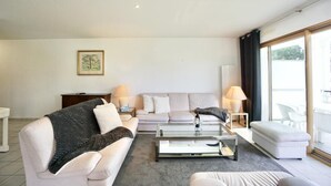 Een moderne woonkamer met een bank, een salontafel en een bijzettafeltje met lampen.