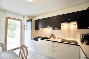 A modern kitchen with a dishwasher, stove, and cabinets.