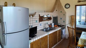 A compact kitchen with a refrigerator, sink, and wooden cabinets. - Casa Vacanze Relax Etna With Stunning Natural Beauty View (Giarre)