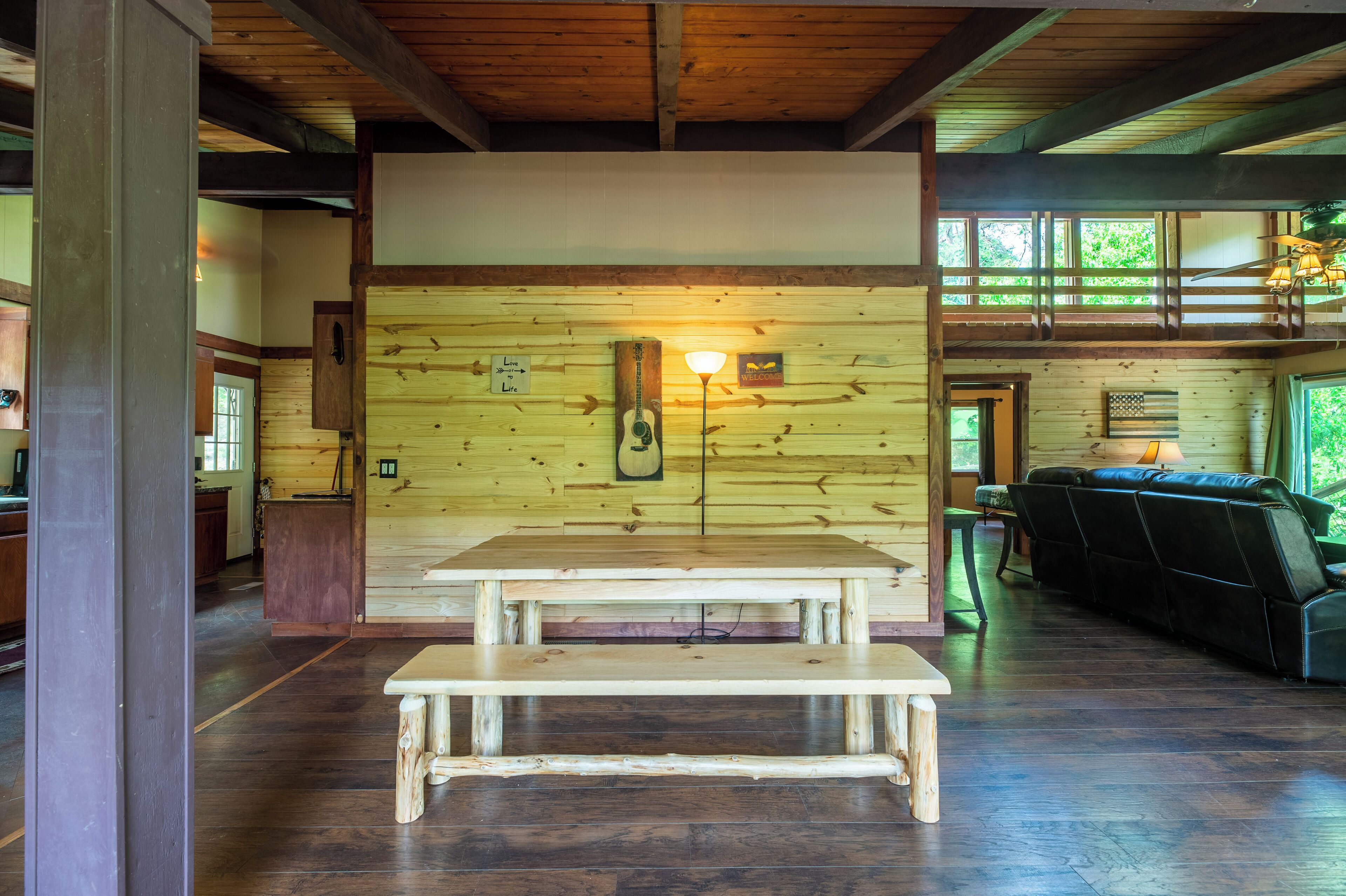 A wooden interior with a wooden bench, a table, and a sofa.