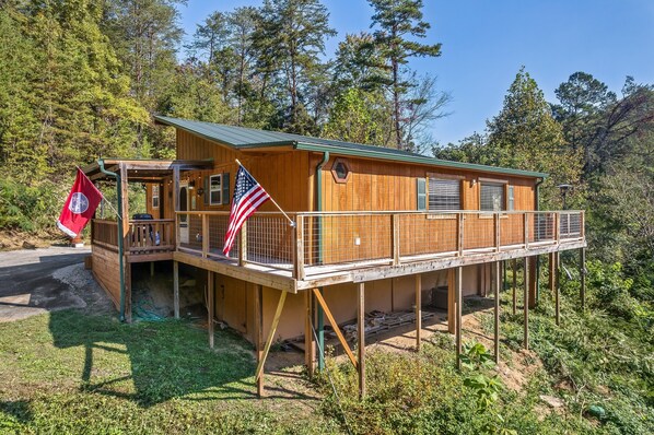 Eine Holzhütte mit Balkon, umgeben von Bäumen.