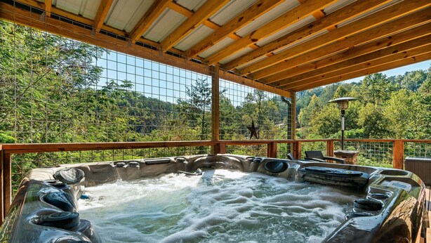 A hot tub with a wooden roof and a view of lush greenery.