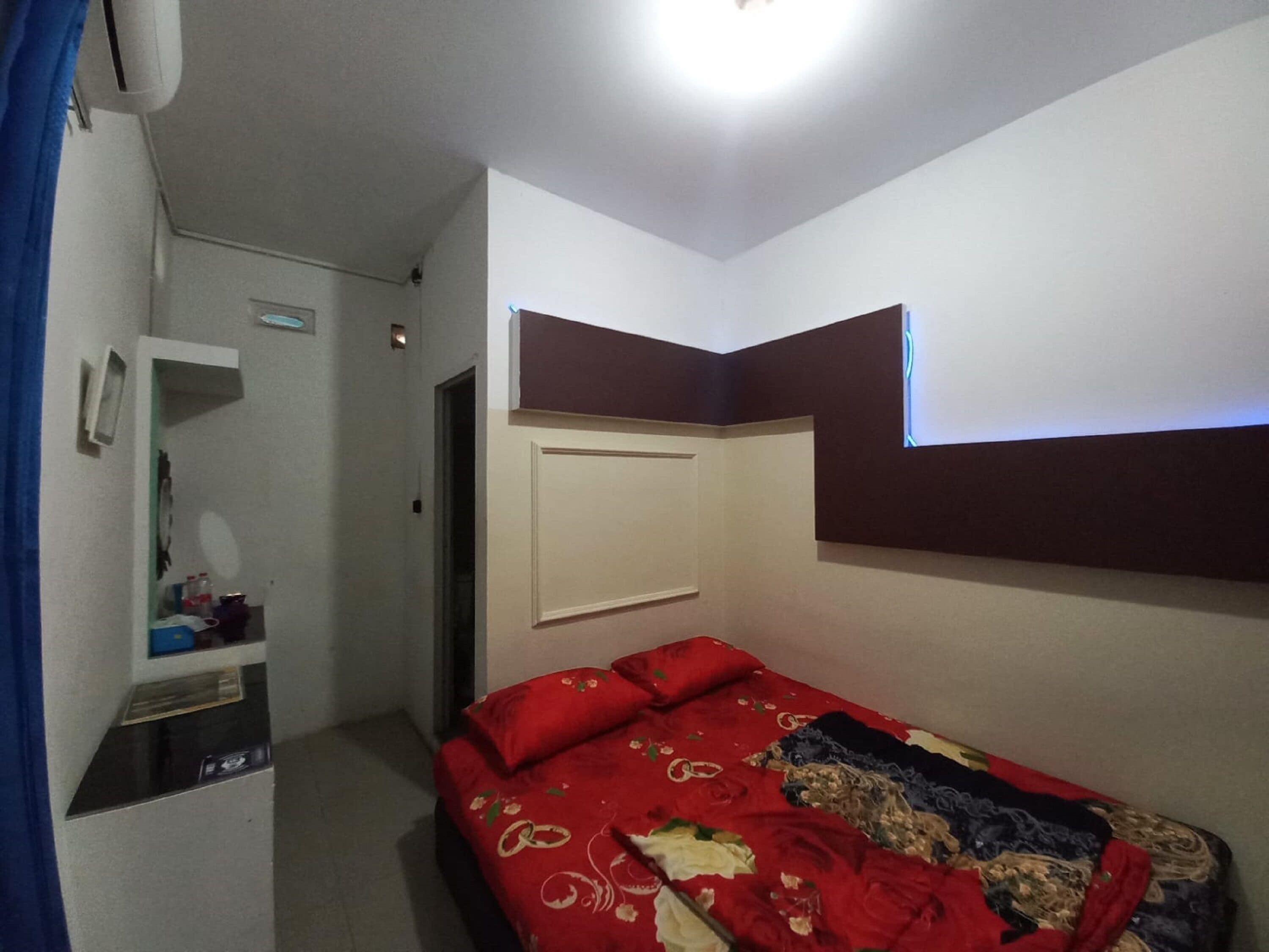 A bedroom with a bed, a wardrobe, and a built-in shelf.