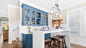 A kitchen with a blue cabinet, white countertop, and wooden stools. - Perfect for Groups - Pet Friendly, 1 Min to Beach, Private Pool, LSV, and more! (Santa Rosa Beach)