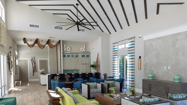 Un vaste espace de vie comprenant une cuisine moderne, un coin repas et un salon aménagé avec des canapés et des fauteuils.