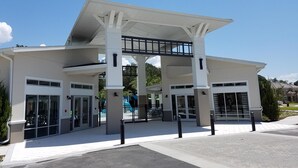 Un bâtiment moderne doté d’une entrée couverte, de grandes fenêtres et d’une allée menant à un portail.