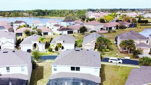 A residential area with houses, a swimming pool, and a lake in the background. - Gorgeous 6Bd Pool Hm Providence-2256CA (Davenport)