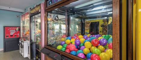 A claw machine filled with colorful balls, a 'ToyShoppe' sign, and a 'Change' coin dispenser.