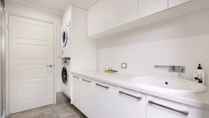 A modern bathroom with a white sink, a mirror, and a towel rack. - The Bay Retreat (Dunsborough)