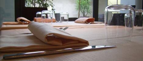 Una mesa dispuesta con un mantel doblado, un tenedor y una copa.