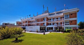 Hotel de varios pisos con un patio central, con un diseño arquitectónico moderno que incorpora ladrillo y vidrio.