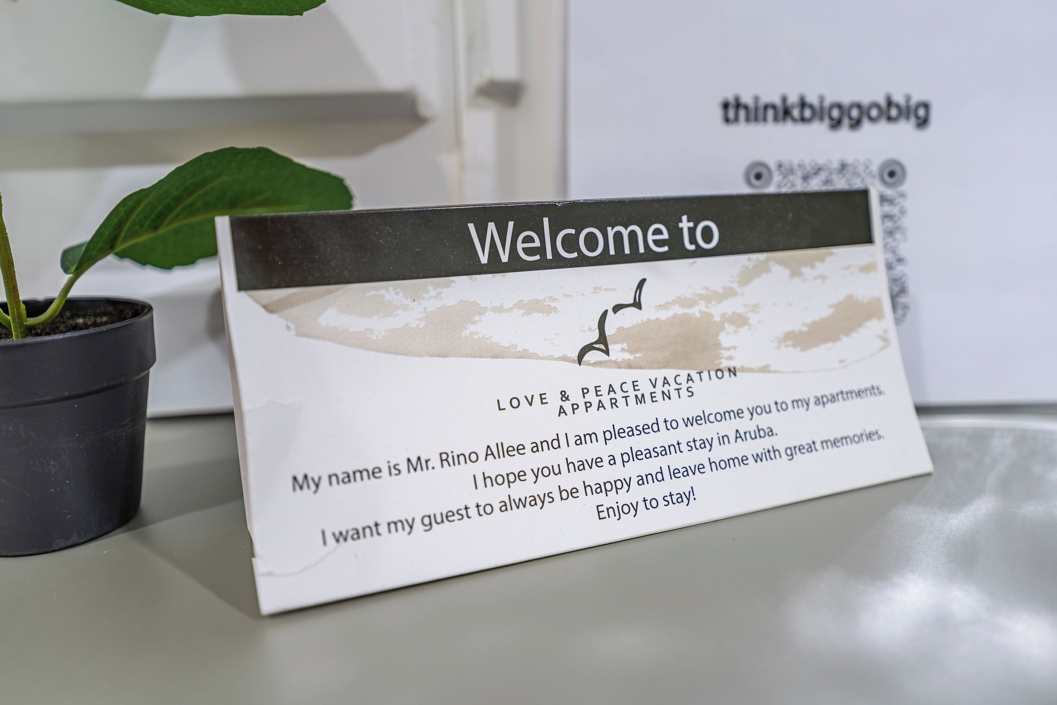 A welcome card with a bird illustration, a name, and a message for guests.
