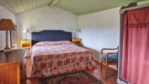 Une chambre à coucher avec un lit, des tables de chevet, une chaise, une lampe et un tapis.