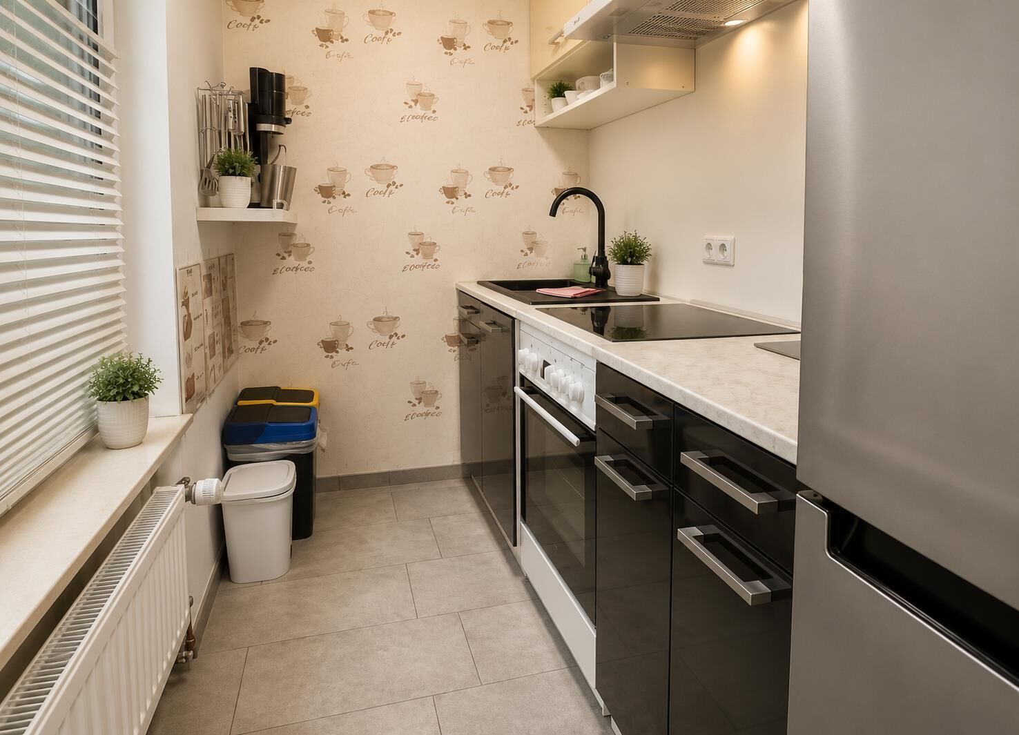 Een kleine keuken met een inbouwoven, een spoelbak en een koelkast.
