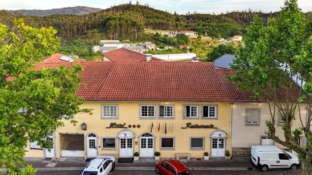 A hotel with a red-tiled roof, a yellow facade, and a sign indicating it is a restaurant. - Hotel Ulveira (Oliveira de Frades)