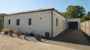 A modern building with a flat roof, a small entrance, and a paved driveway. - Villa Agapanthes, perfect in any season, with heated swimming pool (Saint-Vincent-sur-Jard)